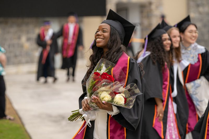 A graduate smiles during a commencement ceremony in lane stadium