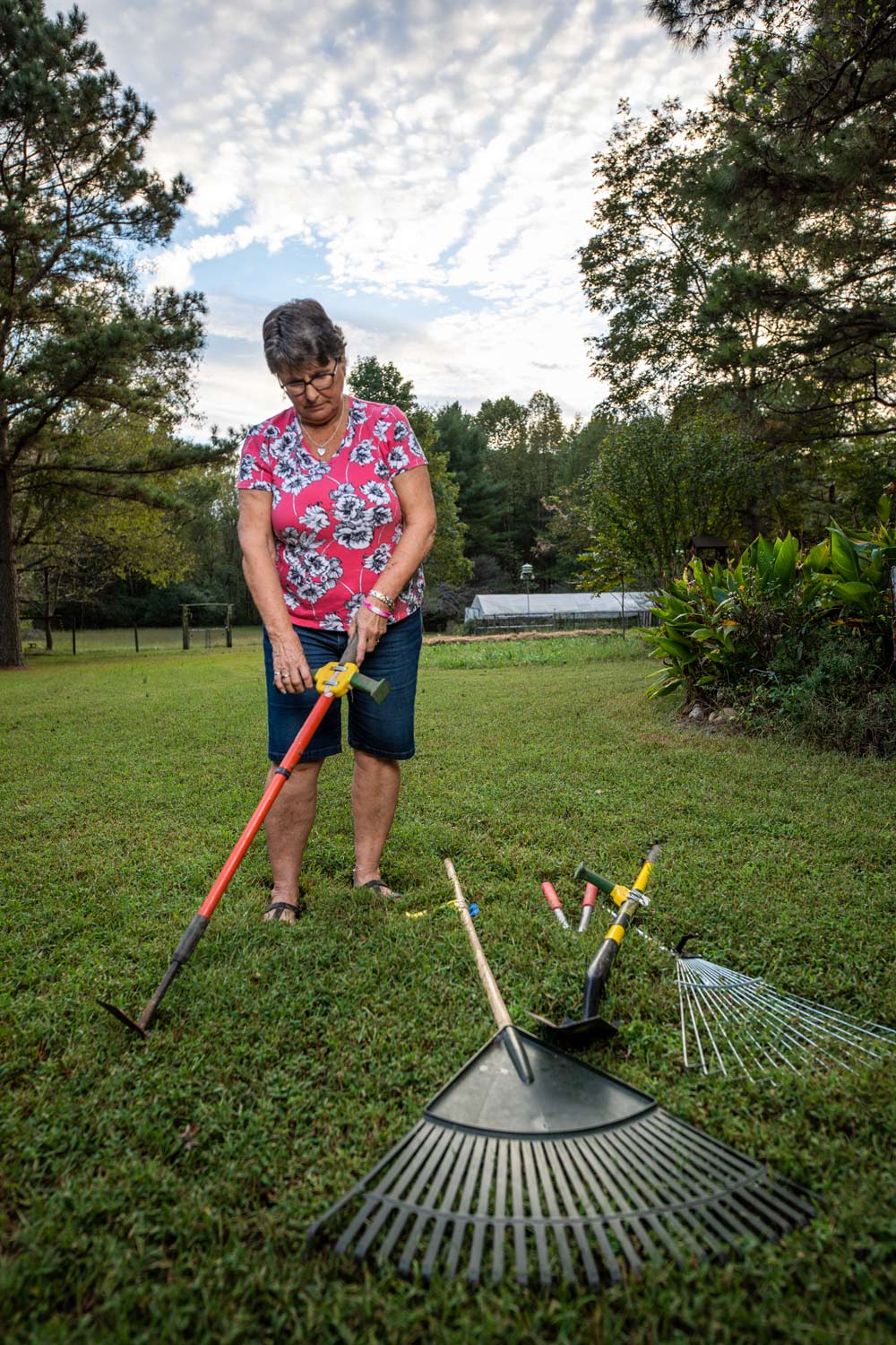 A woman holds a tool that has handles built onto the sides.