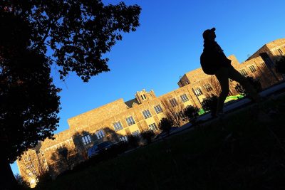 Student walks in front of Torgersen Hall