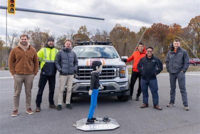 group of researchers standing in front of a truck