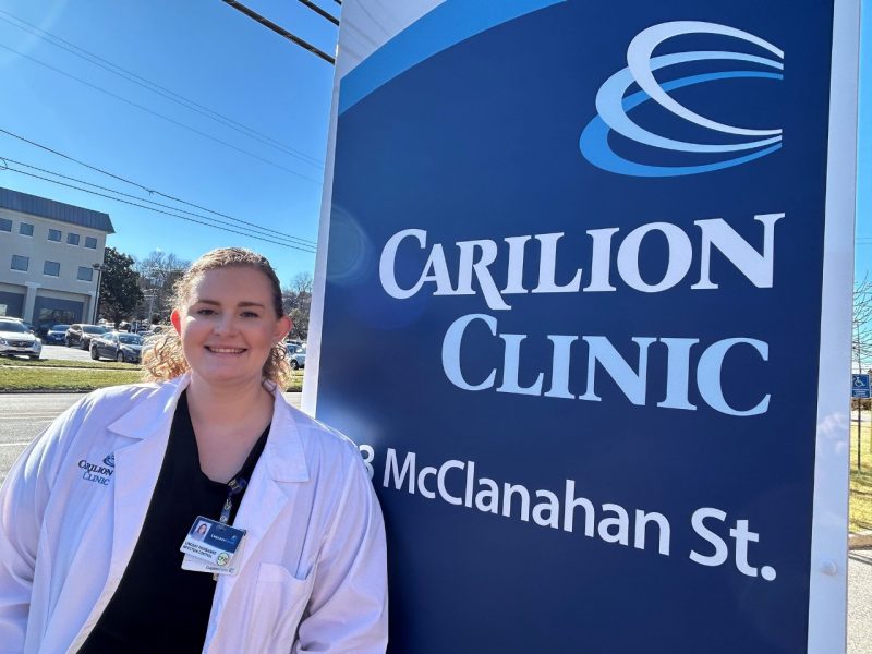 Lindsay Fairbanks standing in front of a Carilion Clinic sign.