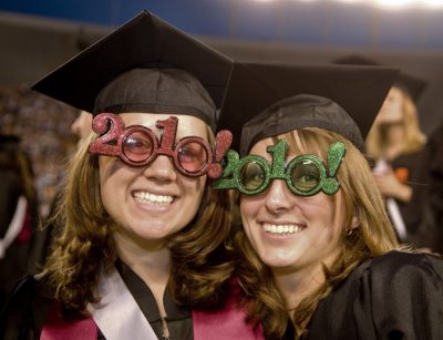 Smiling graduates wear 2010-rimmed glasses at the University Commencement Ceremony