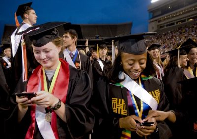 Graduates use cell phones and PDAs at the University Commencement Ceremony