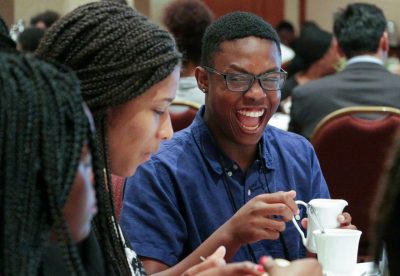 Provoked by friends, Eric Jones bursts into laughter during an etiquette lunch in the Latham Ballroom at The Inn at Virginia Tech. 