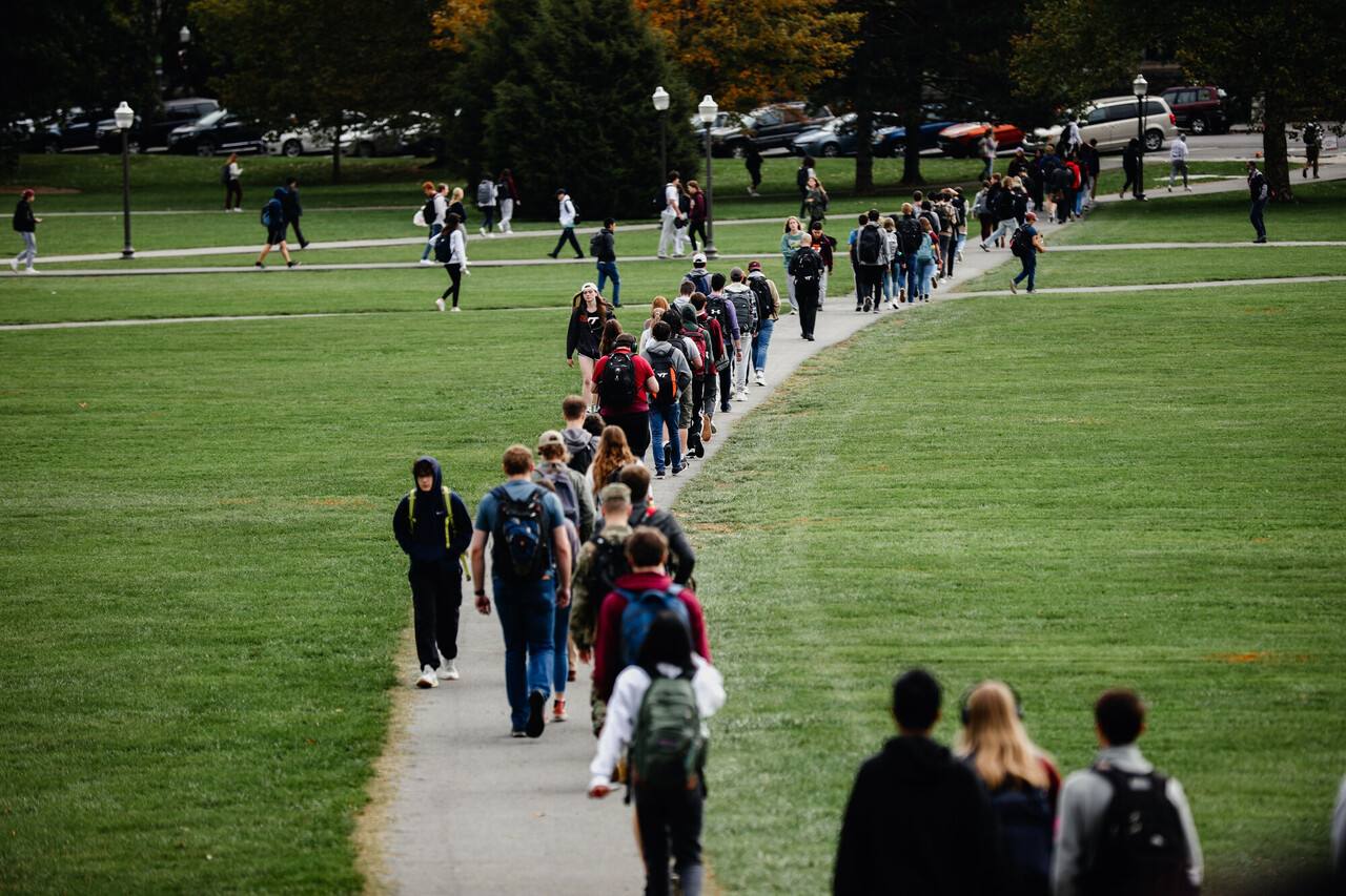 Students walk along a path on the Drillfield