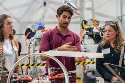A Virginia Tech student using a 3D printer in front of industry executives