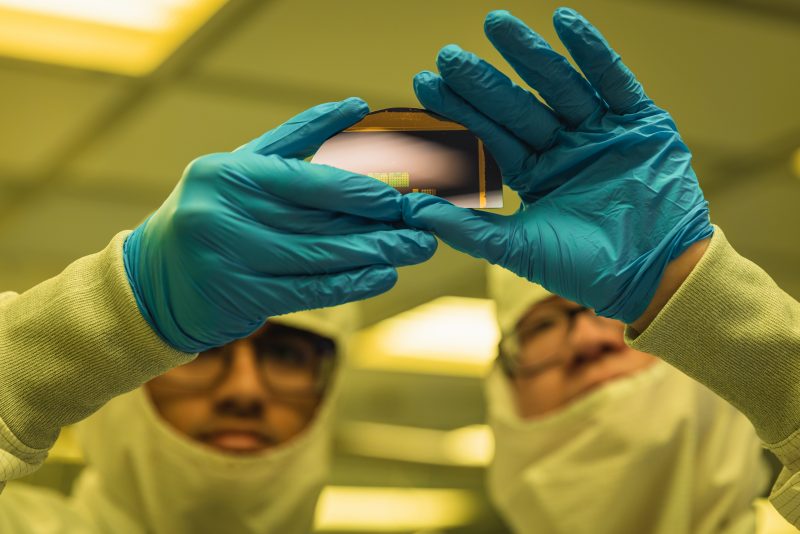 Two students in the College of Engineering fabricate semiconductors in a clean lab. 