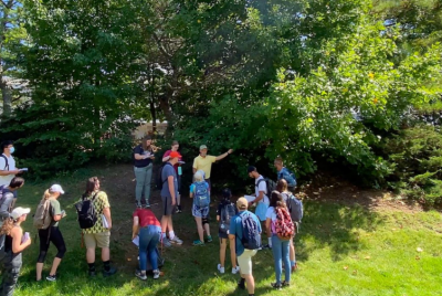 CNRE students gathering around a campus tree with professor