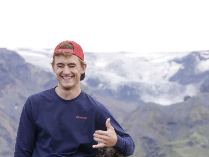 photo of a young college graduate against a mountain background